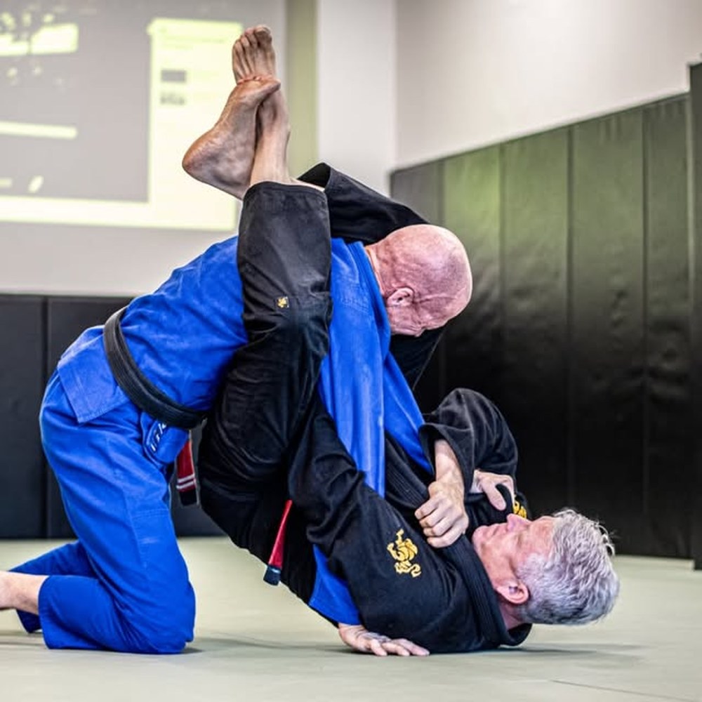 Two black belts rolling on the mat